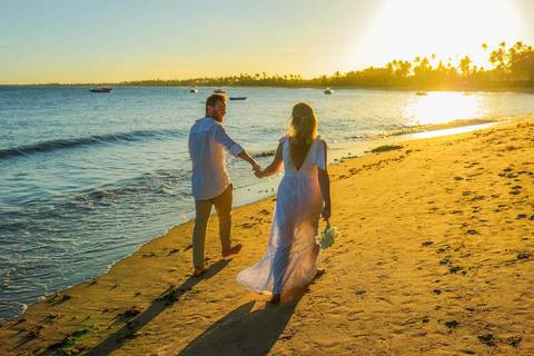 O que fazer em Praia do Forte Bahia, Fotógrafo em PRAIA DO FORTE BAHIA, WALDYR LANTYER Noivos caminhando na areia da Praia do Forte durante o pôr do sol, celebrando um casamento intimista na praia na Bahia.'