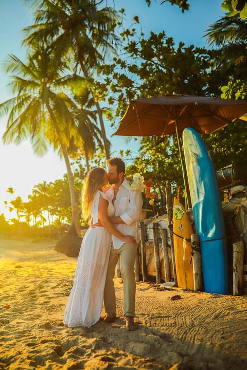 O que fazer em Praia do Forte Bahia, Fotógrafo em PRAIA DO FORTE BAHIA, WALDYR LANTYER Noivos caminhando na areia da Praia do Forte durante o pôr do sol, celebrando um casamento intimista na praia na Bahia.'