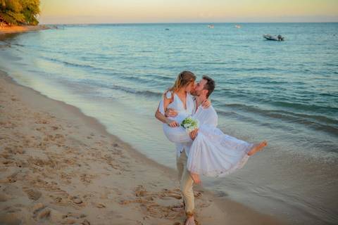 O que fazer em Praia do Forte Bahia, Fotógrafo em PRAIA DO FORTE BAHIA, WALDYR LANTYER.  Casal recém-casado celebrando elopement wedding na Praia do Forte com o céu colorido do crepúsculo ao fundo.'