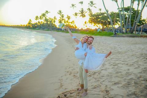 O que fazer em Praia do Forte Bahia, Fotógrafo em PRAIA DO FORTE BAHIA, WALDYR LANTYER.  Casal recém-casado celebrando elopement wedding na Praia do Forte com o céu colorido do crepúsculo ao fundo.'