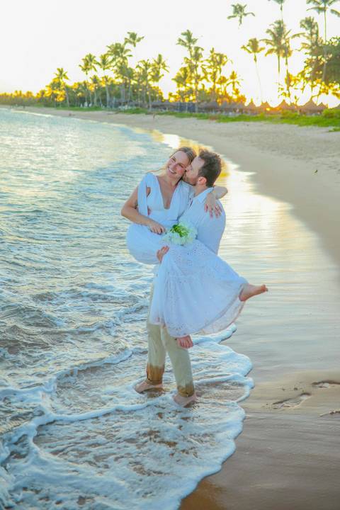 O que fazer em Praia do Forte Bahia, Fotógrafo em PRAIA DO FORTE BAHIA, WALDYR LANTYER. Detalhe da troca de alianças de Fabíola e Felipe em cerimônia íntima de casamento na praia ao pôr do sol.'