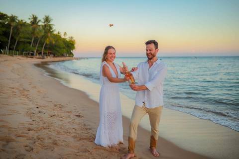 O que fazer em Praia do Forte Bahia, Fotógrafo em PRAIA DO FORTE BAHIA, WALDYR LANTYER. Detalhe da troca de alianças de Fabíola e Felipe em cerimônia íntima de casamento na praia ao pôr do sol.'
