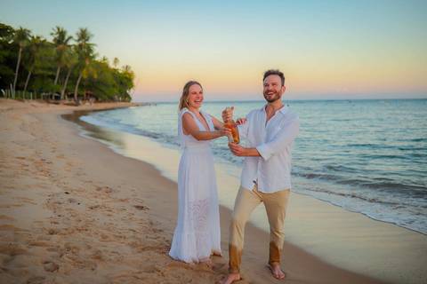 O que fazer em Praia do Forte Bahia, Fotógrafo em PRAIA DO FORTE BAHIA, WALDYR LANTYER. Detalhe da troca de alianças de Fabíola e Felipe em cerimônia íntima de casamento na praia ao pôr do sol.'