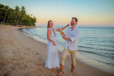 O que fazer em Praia do Forte Bahia, Fotógrafo em PRAIA DO FORTE BAHIA, WALDYR LANTYER. Detalhe da troca de alianças de Fabíola e Felipe em cerimônia íntima de casamento na praia ao pôr do sol.'