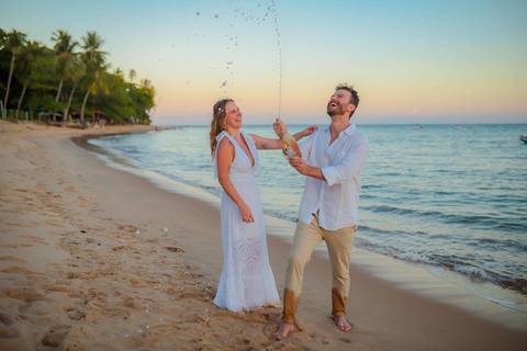 O que fazer em Praia do Forte Bahia, Fotógrafo em PRAIA DO FORTE BAHIA, WALDYR LANTYER. Detalhe da troca de alianças de Fabíola e Felipe em cerimônia íntima de casamento na praia ao pôr do sol.'