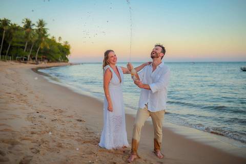 O que fazer em Praia do Forte Bahia, Fotógrafo em PRAIA DO FORTE BAHIA, WALDYR LANTYER. Detalhe da troca de alianças de Fabíola e Felipe em cerimônia íntima de casamento na praia ao pôr do sol.'