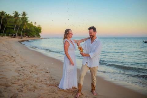 O que fazer em Praia do Forte Bahia, Fotógrafo em PRAIA DO FORTE BAHIA, WALDYR LANTYER. Detalhe da troca de alianças de Fabíola e Felipe em cerimônia íntima de casamento na praia ao pôr do sol.'