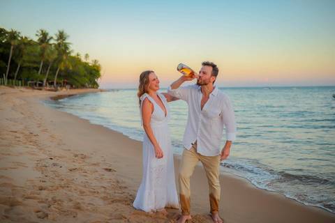 O que fazer em Praia do Forte Bahia, Fotógrafo em PRAIA DO FORTE BAHIA, WALDYR LANTYER. Detalhe da troca de alianças de Fabíola e Felipe em cerimônia íntima de casamento na praia ao pôr do sol.'