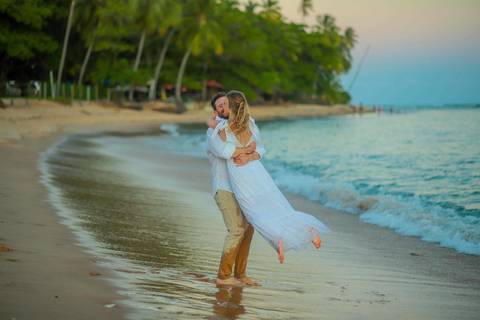 O que fazer em Praia do Forte Bahia, Fotógrafo em PRAIA DO FORTE BAHIA, WALDYR LANTYER. Casamento na praia ao pôr do sol com os noivos celebrando o amor em cenário natural na Praia do Forte, Bahia.'
