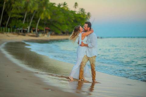 O que fazer em Praia do Forte Bahia, Fotógrafo em PRAIA DO FORTE BAHIA, WALDYR LANTYER. Casamento na praia ao pôr do sol com os noivos celebrando o amor em cenário natural na Praia do Forte, Bahia.'