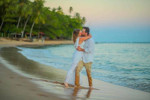 O que fazer em Praia do Forte Bahia, Fotógrafo em PRAIA DO FORTE BAHIA, WALDYR LANTYER. Casamento na praia ao pôr do sol com os noivos celebrando o amor em cenário natural na Praia do Forte, Bahia.'