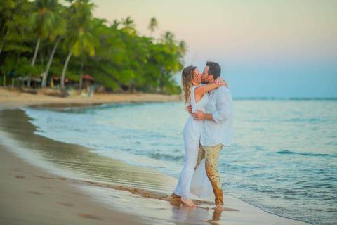 O que fazer em Praia do Forte Bahia, Fotógrafo em PRAIA DO FORTE BAHIA, WALDYR LANTYER. Casamento na praia ao pôr do sol com os noivos celebrando o amor em cenário natural na Praia do Forte, Bahia.'