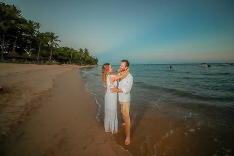 O que fazer em Praia do Forte Bahia, Fotógrafo em PRAIA DO FORTE BAHIA, WALDYR LANTYER. Ensaio de casal na Praia do Forte com mar e céu dourado criando cenário romântico para casamento intimista.'