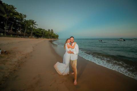 Noivos se beijando ao pôr do sol na Praia do Forte durante elopement wedding com luz quente do entardecer.'