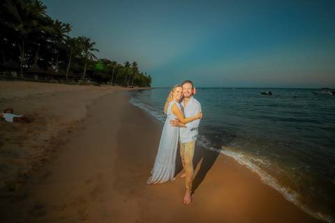 Noivos se beijando ao pôr do sol na Praia do Forte durante elopement wedding com luz quente do entardecer.'