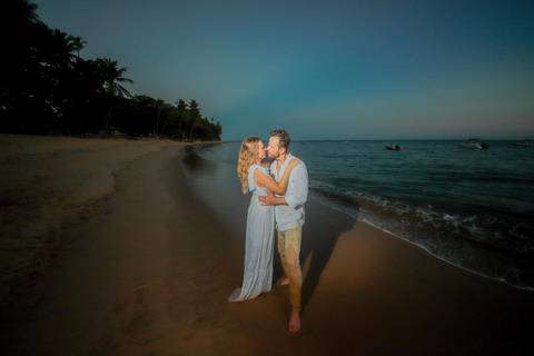 Noivos se beijando ao pôr do sol na Praia do Forte durante elopement wedding com luz quente do entardecer.'