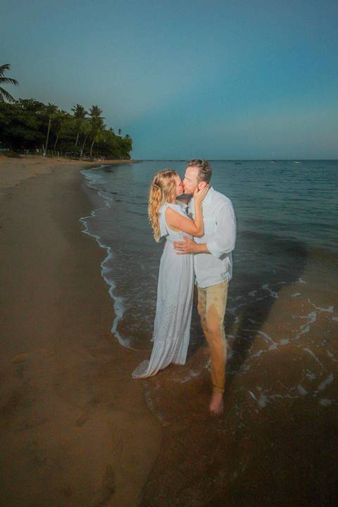 Noivos se beijando ao pôr do sol na Praia do Forte durante elopement wedding com luz quente do entardecer.'