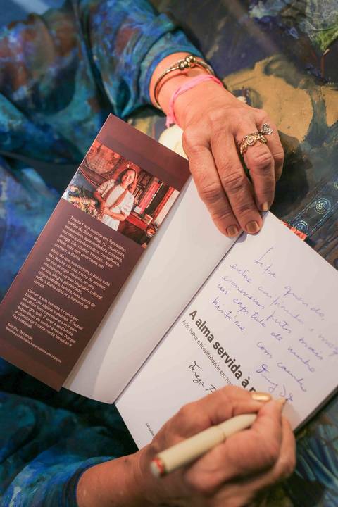 Eternizar o momento em que a chef Tereza Paim autografa seu novo livro é capturar a essência de sua trajetória. Cada assinatura carrega o afeto, a dedicação e o orgulho de quem dedica a vida a valorizar os sabores e as tradições da nossa terra.'