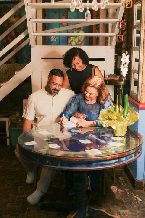 Eternizar o momento em que a chef Tereza Paim autografa seu novo livro é capturar a essência de sua trajetória. Cada assinatura carrega o afeto, a dedicação e o orgulho de quem dedica a vida a valorizar os sabores e as tradições da nossa terra.'