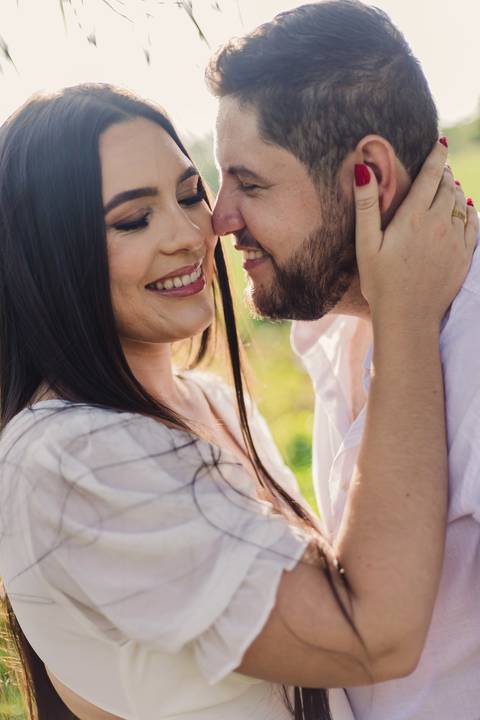 Retrato aproximado de Jaque e Mateus sorrindo e demonstrando carinho durante o ensaio pré-casamento.'