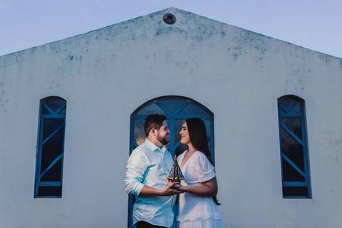 Jaque e Mateus em frente a uma pequena igreja da zona rural durante o ensaio pré-casamento.'