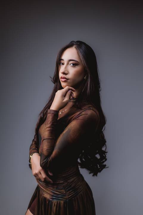 Retrato aproximado de Layla durante seu ensaio de 18 anos, com pose delicada e iluminação de estúdio.'