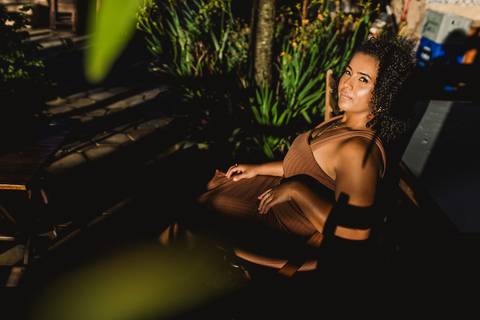 Retrato de Neide utilizando luz e sombra entre a vegetação durante seu ensaio feminino.'