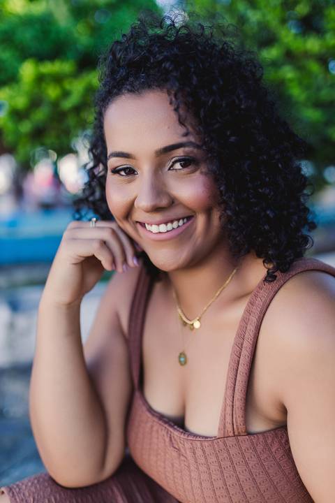 Retrato aproximado de Neide sorrindo durante ensaio feminino ao ar livre.'