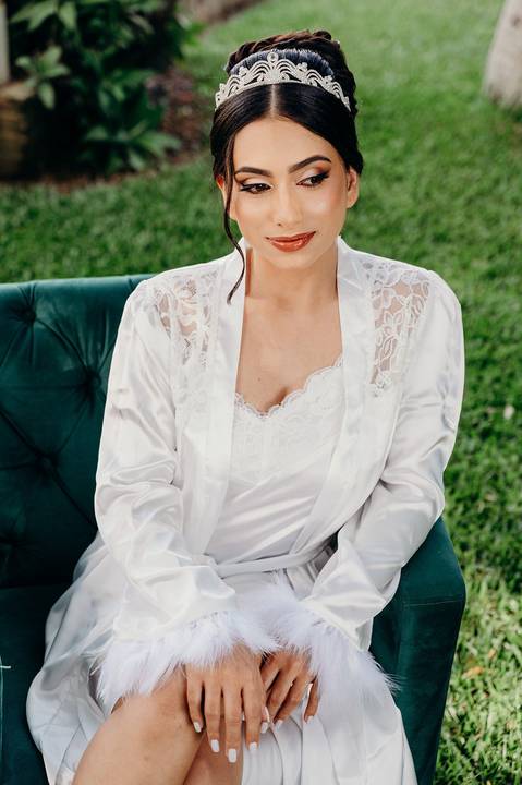 a noiva sentada em um sofá verde com hobbi branco'