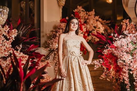 Debutante na escadaria com muitas flores em volta
'