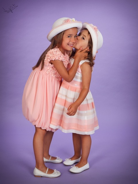 fotografia de estúdio irmãs a dar beijo'
