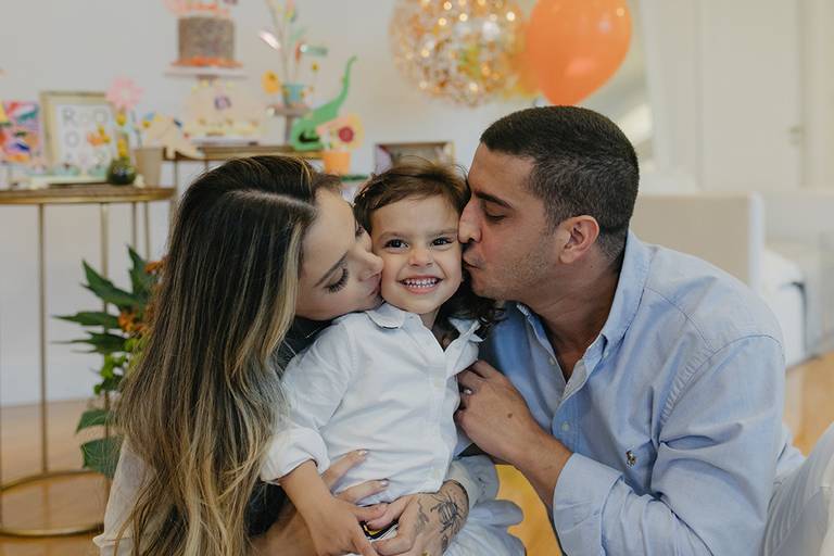 pais beijando bochecha crianca festa infantil em casa