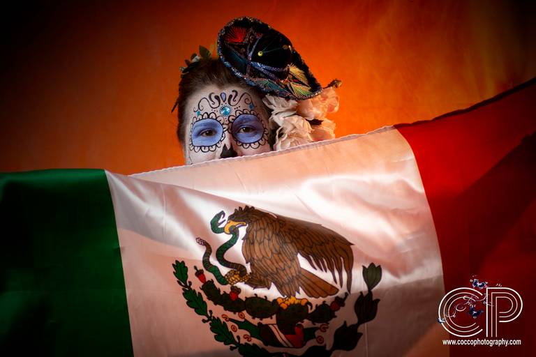 catrina con bandera mexicana en sesion de fotos para el dia de muertos