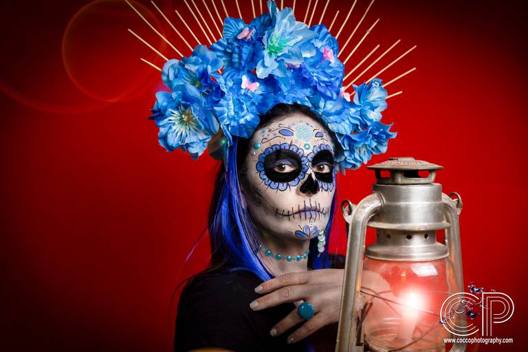 catrina mexicana con maquillaje color azul con lampara para día de muertos, sesión de fotos en rosario