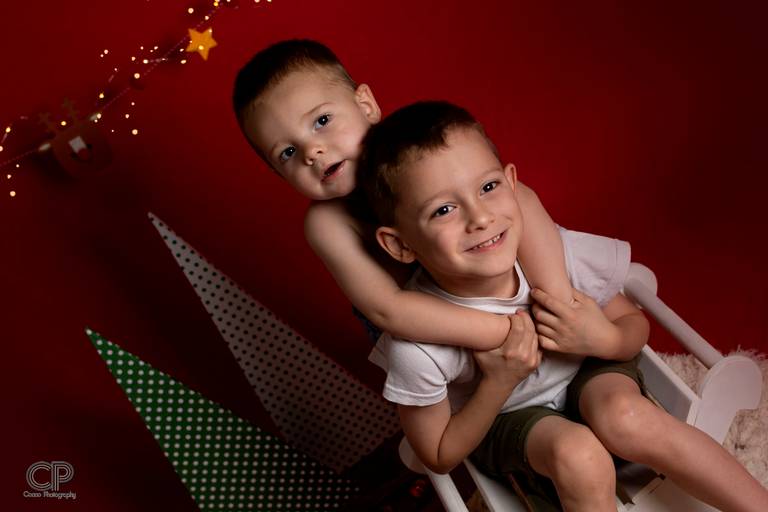 fotos navideñas infaniles en rosario con luces y gorro de papa noel, fotos divertidas de navidad, sesiones navideñas en familia, fotos de papa noel