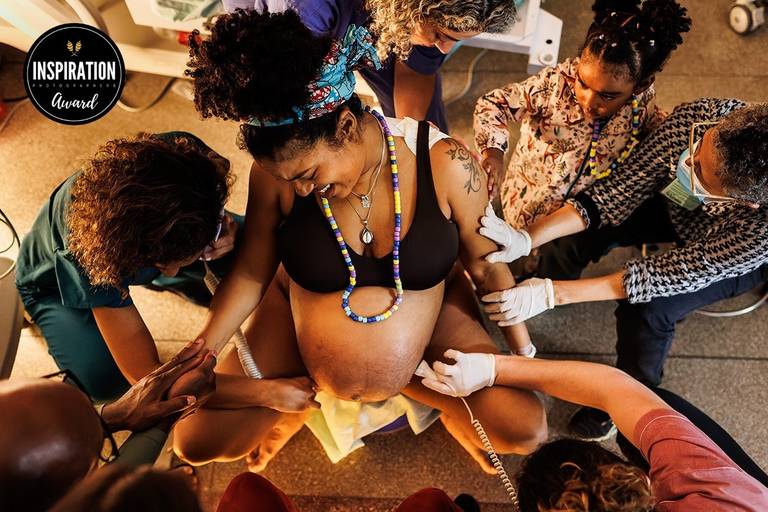 Adriana Costa foi premiada pela Inspiration Family Awards pela foto de uma uma gestante sendo apoiada na hora do nascimento de seus gêmeos por sua equipe e família