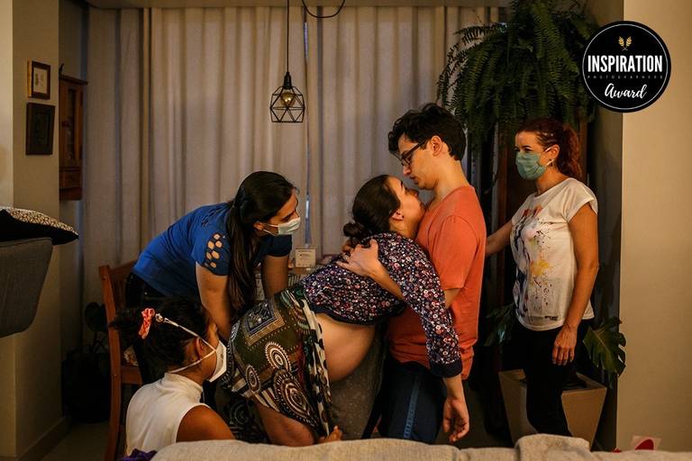 Adriana Costa foi premiada pela Inspiration Family Awards pela foto de uma mulher sendo amparada pela equipe e pelo marido num parto domiciliar