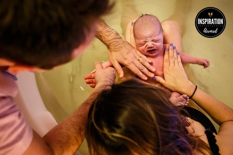 Foto de Adriana Costa de um casal acarinhando seu bebê logo após um parto natural com a equipe do Instituto Nascer foi premiada pela Inspiration Family Awards