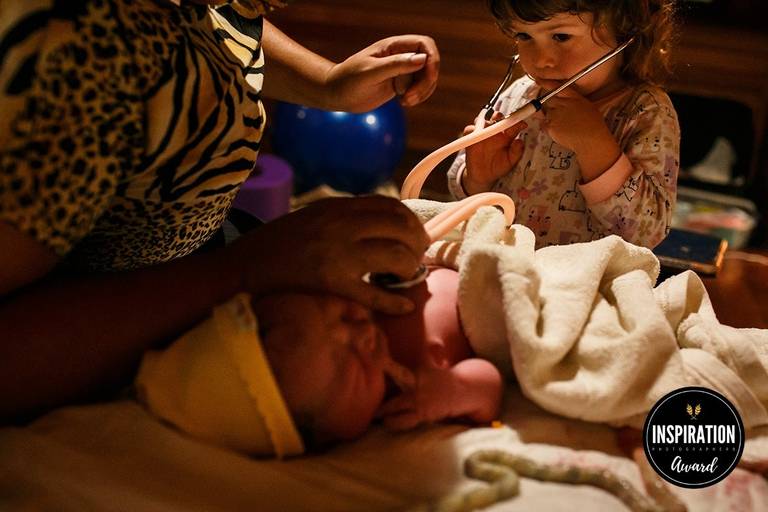 Foto de Adriana Costa da irmã auscultando seu irmãozinho que acabou de nascer de um parto natural domiciliar foi premiada pela Inspiration Family Awards