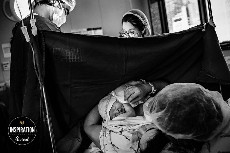 Adriana Costa foi premiada pela Inspiration Family Awards pela foto que mostra a emoção dos pais com sua bebê que nasceu nos braços enquanto os médicos obstetras finalizam a cesárea