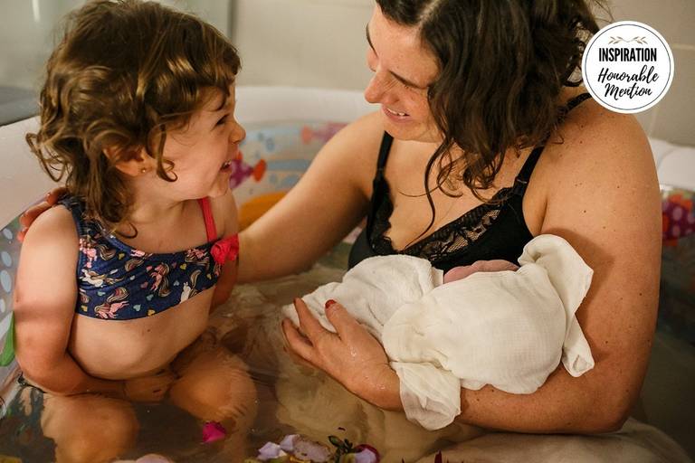 Foto de Adriana Costa da irmã emocionada vendo seu irmão que acabou de nascer de um parto domiciliar recebeu menção honrosa pela Inspiration Family Awards