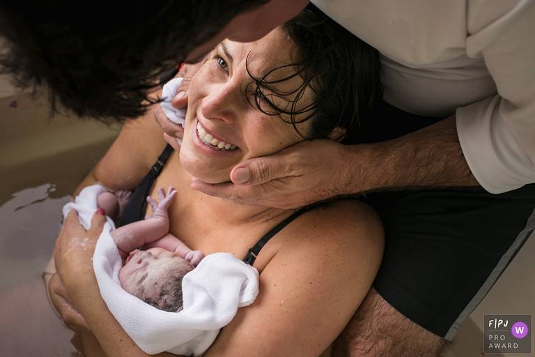 Adriana Costa  recebeu o prêmio internacional pela Associação FPJA (Family Photojournalist Association) na foto de uma mãe e um pai emocionados com o seu bebê que acabou de nascer em um parto domiciliar