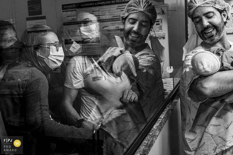 Adriana Costa foi premiada pela  Associação FPJA pela foto do pai orgulhosamente exibindo sua filha recém-nascida para sua família