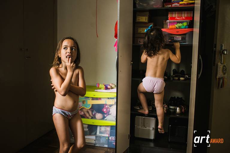 foto premiada pelo décimo terceiro concurso de família pela Fineart Association de duas irmãs brincando no quarto