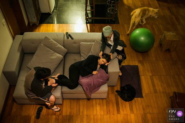 Foto de Adriana Costa de uma parturiente sendo apoiada por sua doula e o marido durante um trabalho de parto domiciliar foi premiada pela Associação FPJA 