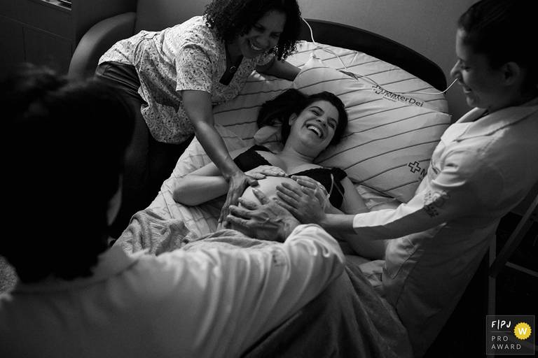 Foto de Adriana Costa de uma parturiente recebendo atenção de sua equipe médica foi premiada pela Associação FPJA