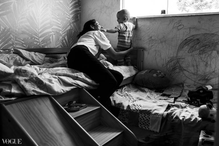 Foto de Adriana Costa selecionada para a galeria da Vogue Itália de uma mãe e seu bebê interagindo num dia comum em casa