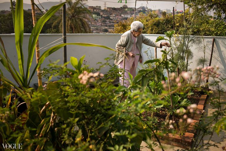 Foto de Adriana Costa selecionada para a galeria da Vogue Itália de um mulher idosa em sua horta ao amanhecer