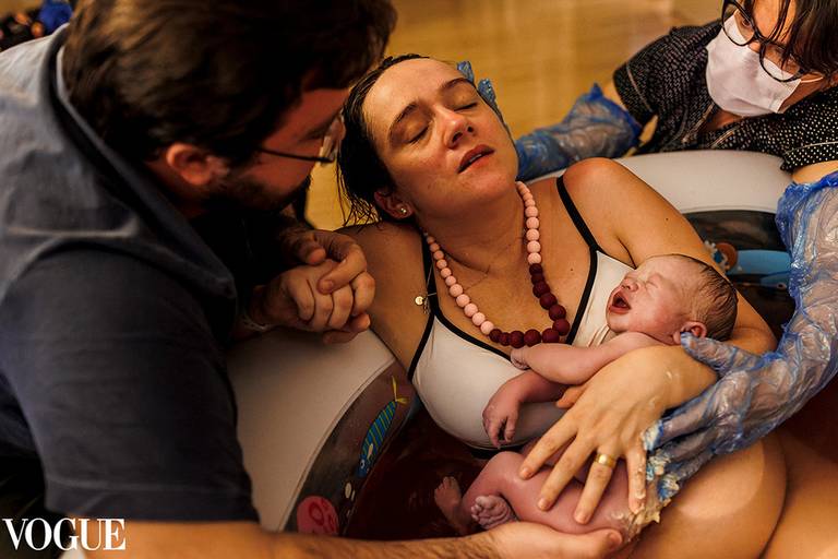 Foto de Adriana Costa selecionada para a galeria da Vogue Itália de uma mãe em momento de êxtase  após o nascimento de sua filha por um parto natural