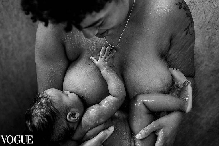 Foto de Adriana Costa selecionada para a galeria da Vogue Itália de um bebê amamentando na hora do banho